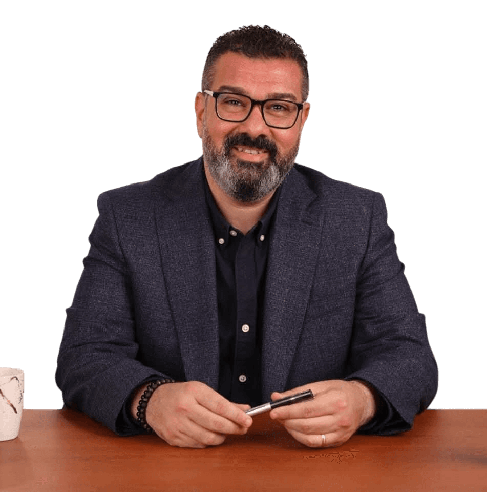 Mr. Tamer Elfangary, American Diploma English consultant and D.SAT & EST coach, smiling at his desk